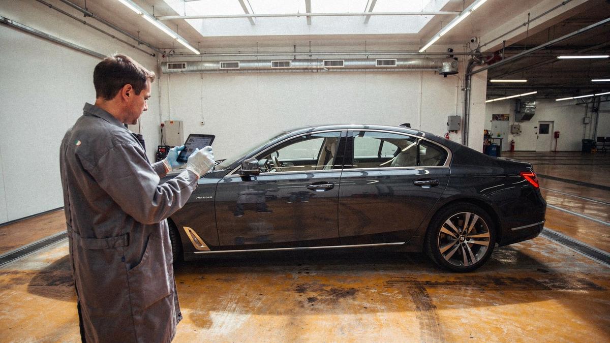 Inspector documenting a luxury sedan during a pre-purchase inspection in Kyiv